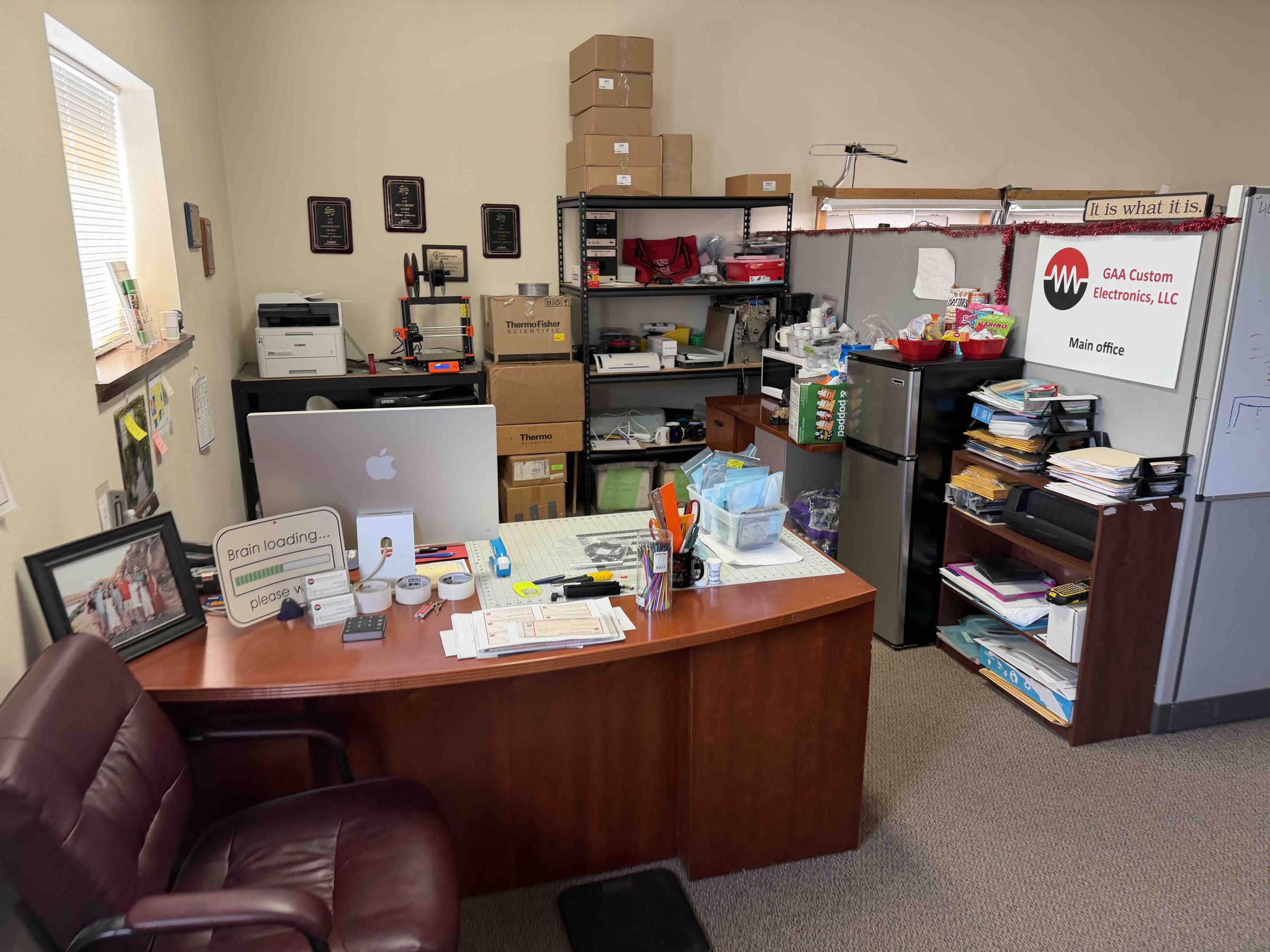 Main office with design workstation, 3D printer, and company awards