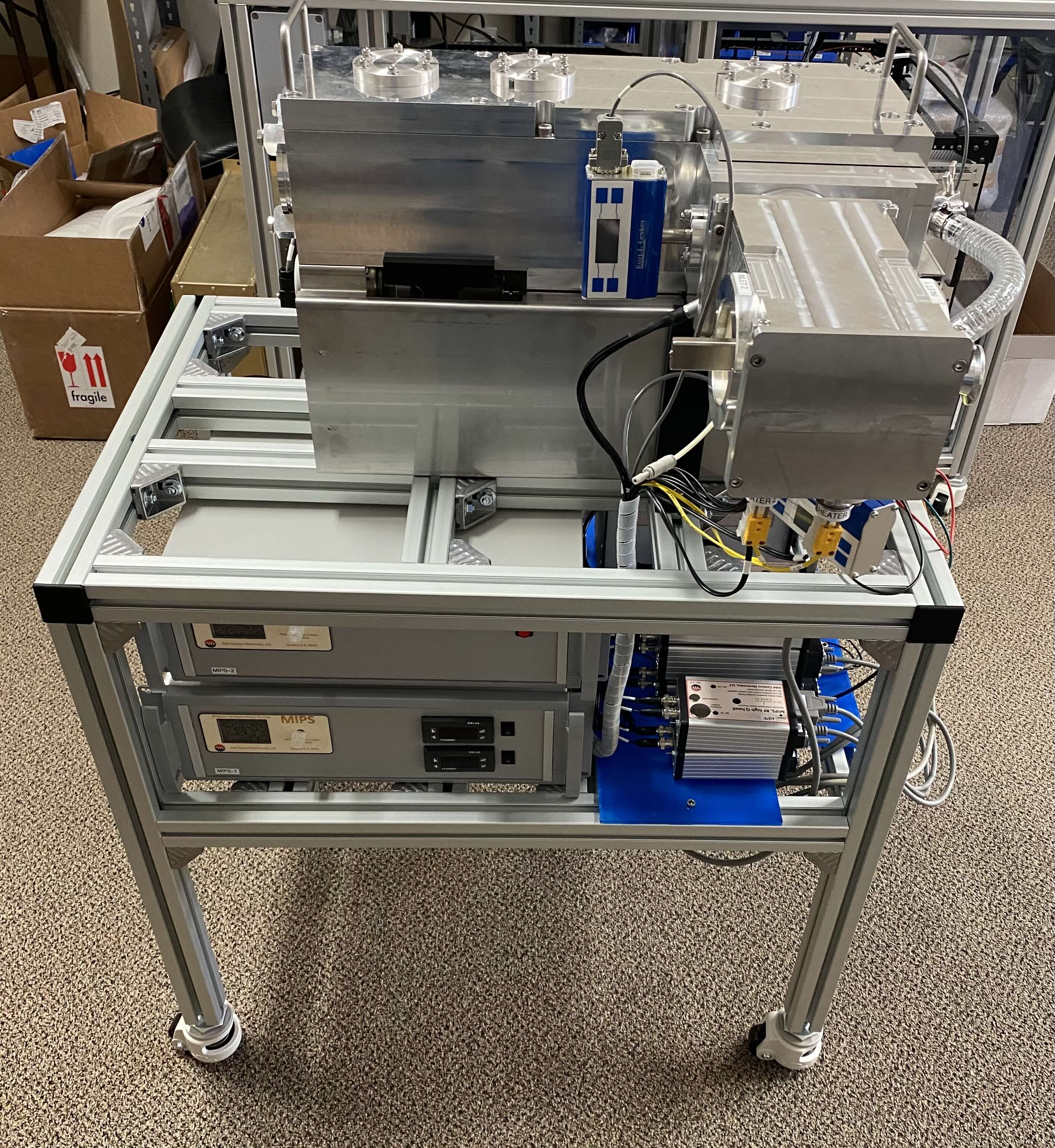 Complete soft landing research system showing two MIPS controllers in rack below vacuum chambers and ion optics assembly mounted on mobile aluminum extrusion cart